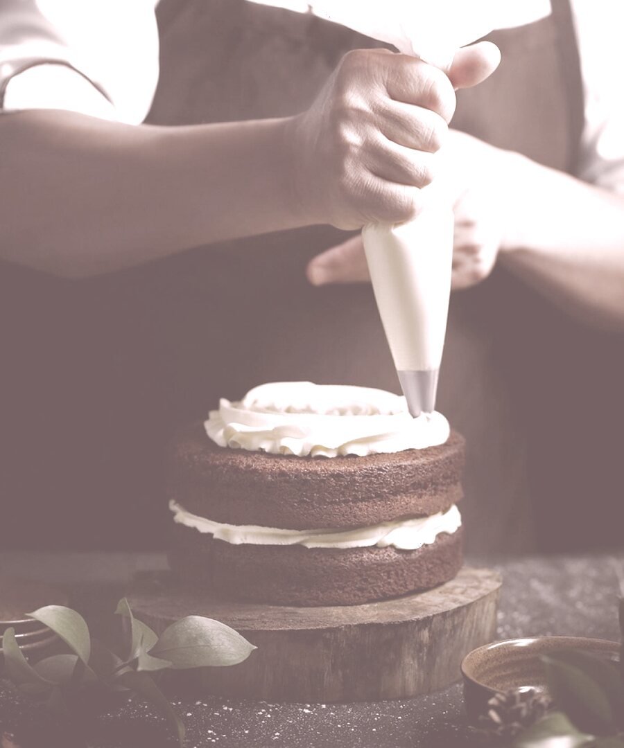 Rita finishing a cake in the studio