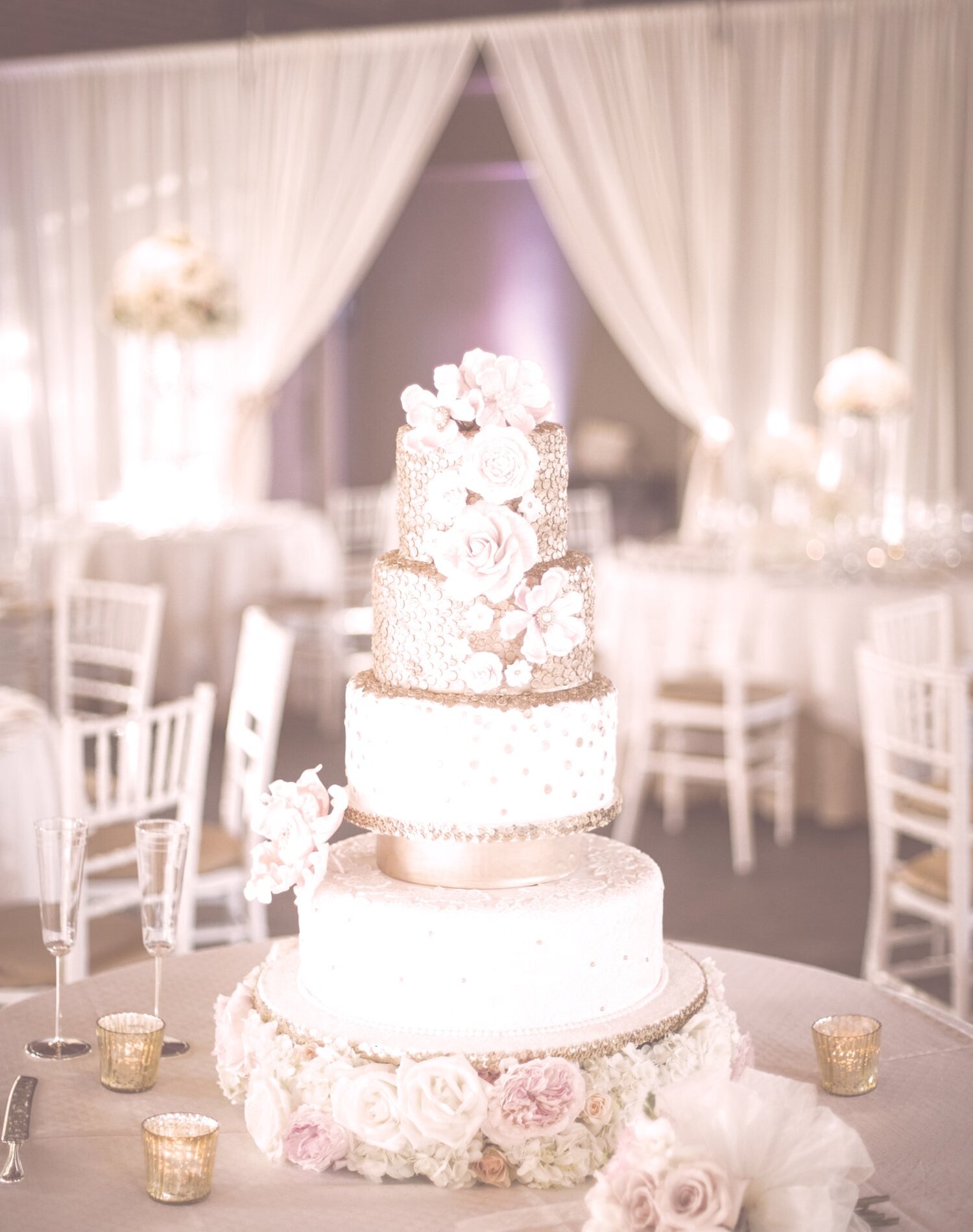 Tiered wedding cake dressed with blush roses